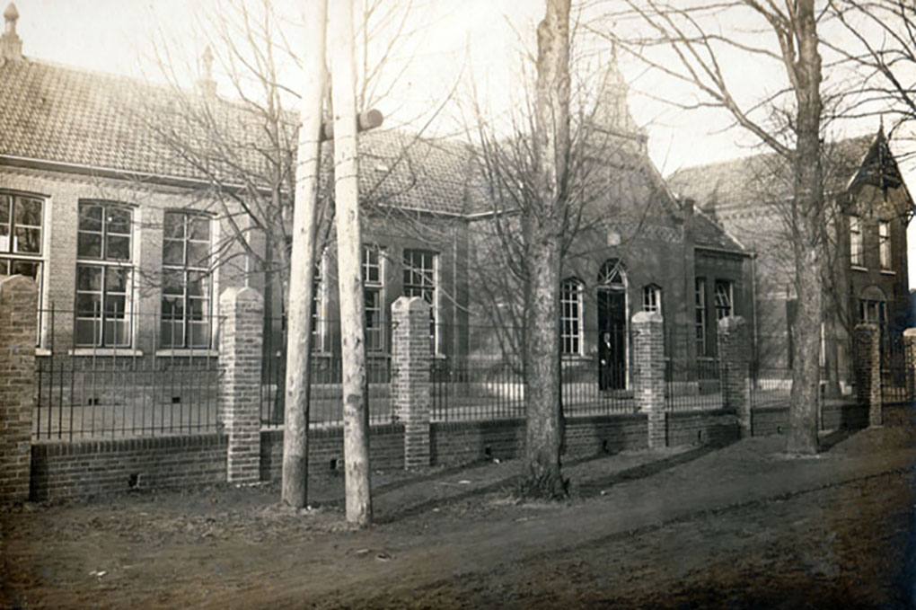De Aloysius jongensschool, hier  is rond de speelplaats (Nog aan de voorkant) een hek geplaatst. je ziet ook de palen voor de electriciteitskabels die toen nog bovengronds waren.